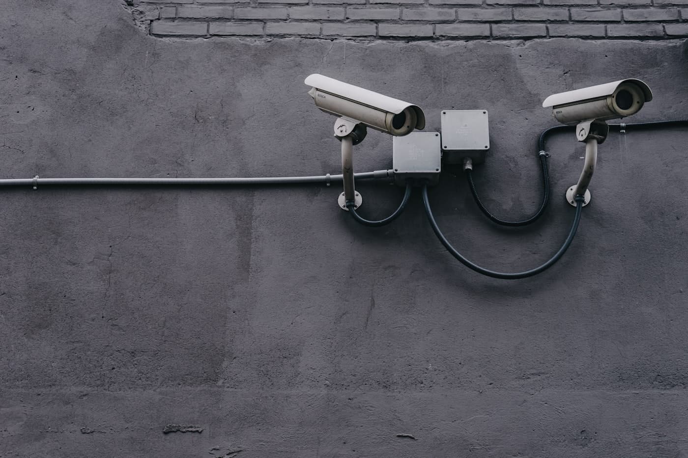 Illustrative photograph of two access-control security cameras mounted on a wall.